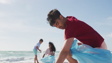familia hispana feliz recogiendo basura en la playa