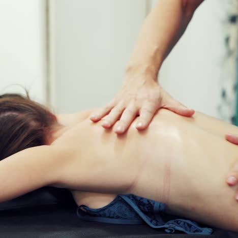 woman enjoying massage in spa salon