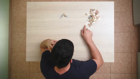 el hombre cuenta el último dinero sentado en la mesa en casa. concepto pobreza y crisis económica