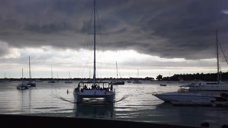 a tourist catamaran arriving a the harbor at sunset