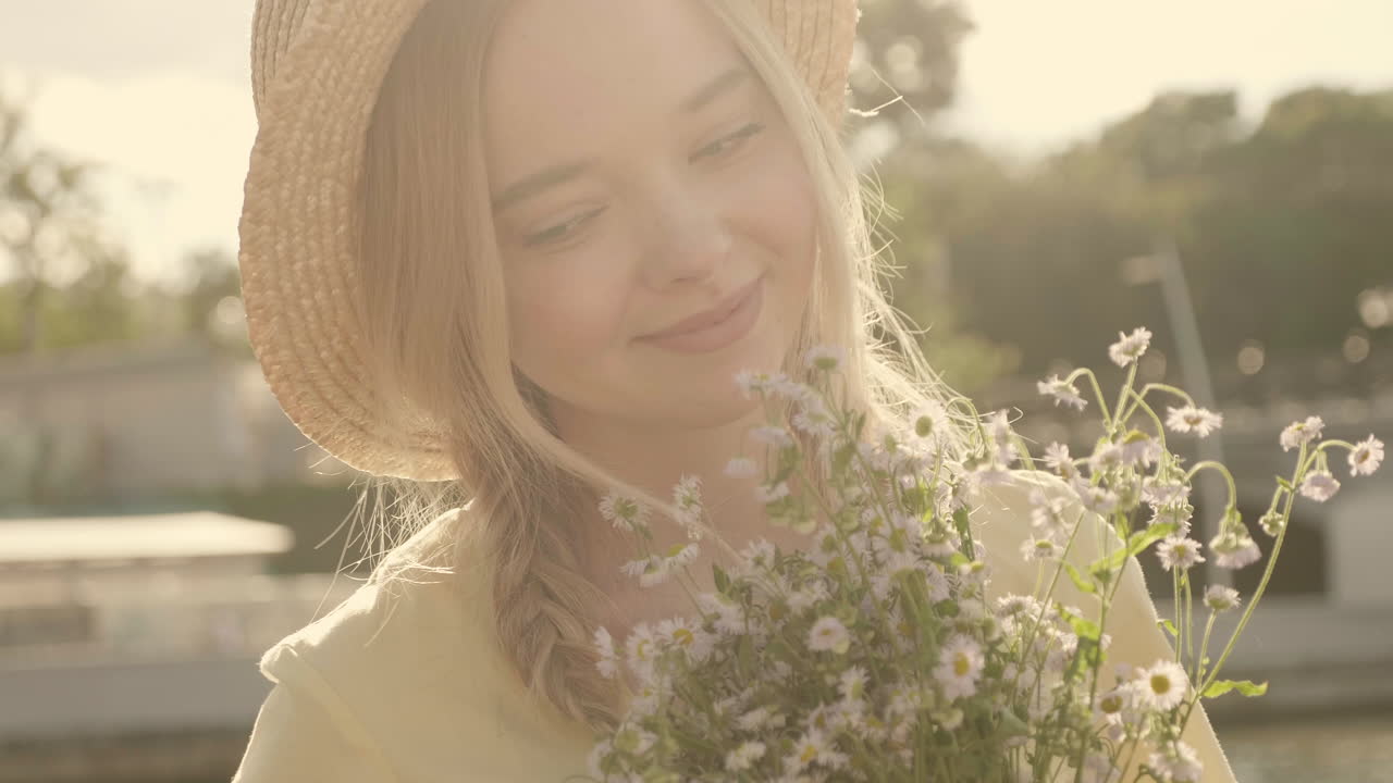Smiling Woman with Flowers in a Straw Hat