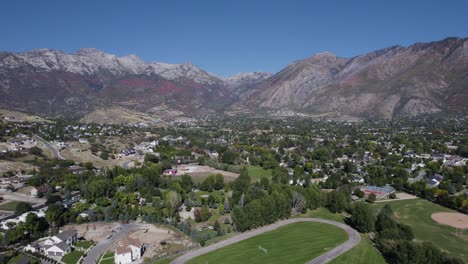 alpine city from above during blue sky day and mountain range in background