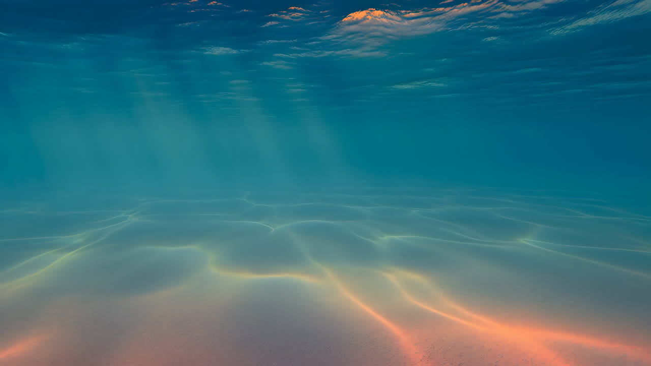 Sunlight Rays Penetrating Clear Blue Underwater into Sandy Seabed