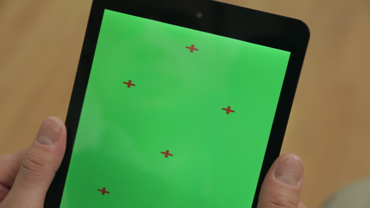 manos masculinas sosteniendo una tableta pc con pantalla de tecla cromática sobre fondo de madera