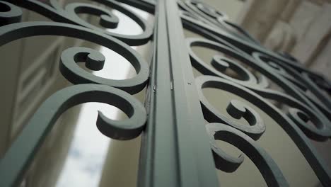 green ornate iron gate with traveling camera in downtown