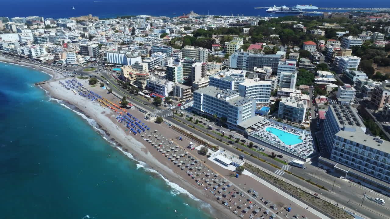 Aerial tracking shot a beach and hotels on the coast of Rhodes city, sunny Greece