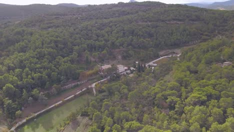 vista aérea de una carretera que conduce a una finca en medio de un bosque