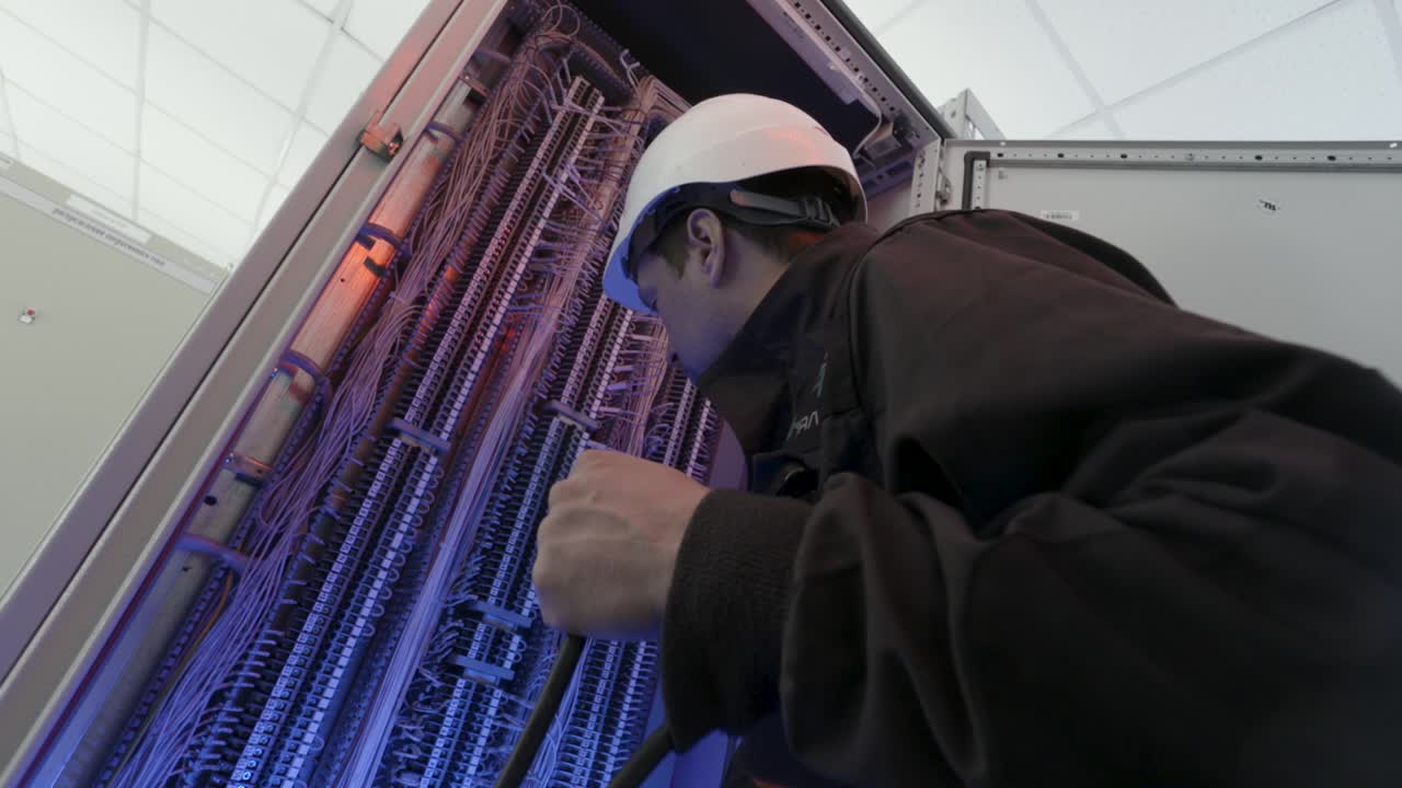 electricista que trabaja en el panel eléctrico