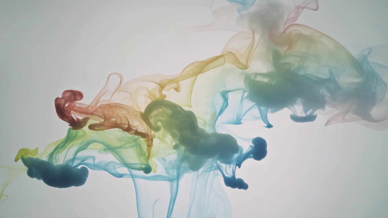 Goccioline colorate che entrano in un serbatoio trasparente, pennacchi di colorante che si espandono e si mescolano, mostrando la miscelazione dei colori