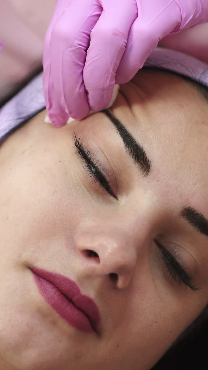 A woman on the procedure of injections in a cosmetology clinic Vertical video