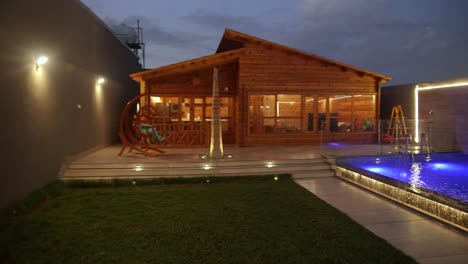 aerial pan left shot of house with lighting decor in pool area