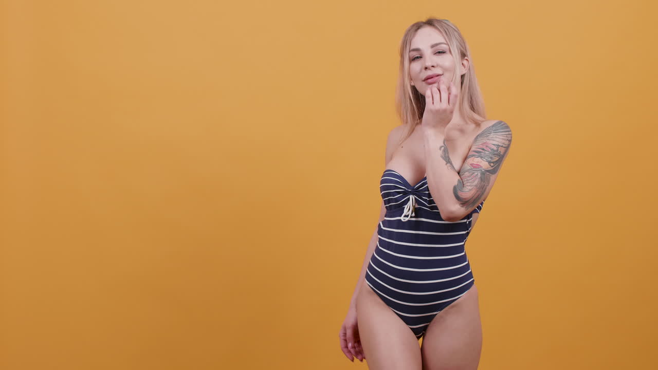 Woman in swimsuit on yellow background