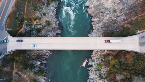 Drone-looking-over-car-bridge-river-crossing-in-Northern-California