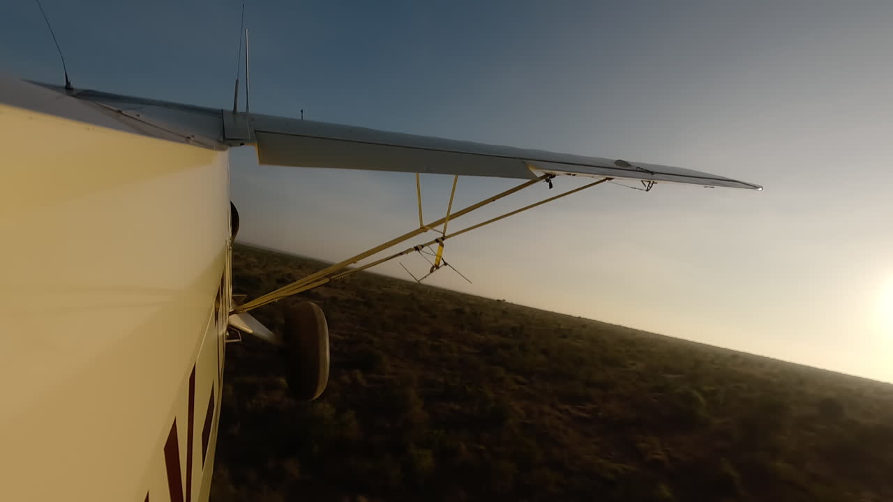 Veduta laterale di un piccolo aereo che vola basso sopra un fiume tra gli arbusti