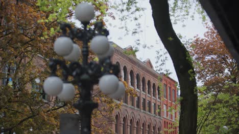 close up of detailed old streetlight, red brick buildings in background on an autumnal day, vancouver, british columbia, canada