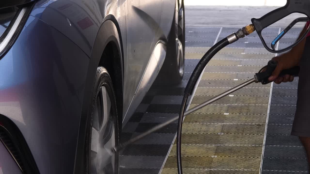 Electric car being washed with high pressure washer