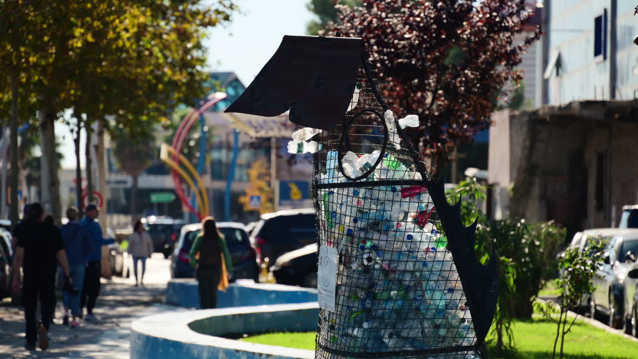 Durazzo, Albania - 13 novembre 2025: Contenitore a rete a forma di pesce in un parco cittadino che raccoglie bottiglie di plastica per il riciclo.