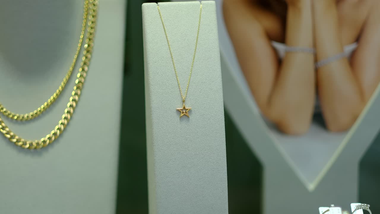 보석 가게 창문에는 금 귀걸이와 보석이 있습니다.