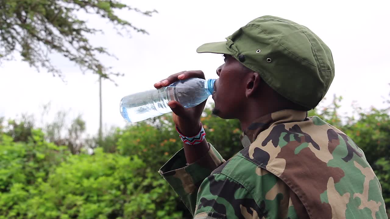 guerrilla militante africana bebiendo agua en un día caluroso