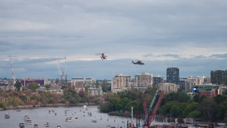 formation of military helicopter convoy flying over brisbane city river during riverfire, 4k slow motion