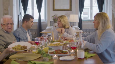 happy family sitting at table in dining room, talking together and enjoying meal at home 3