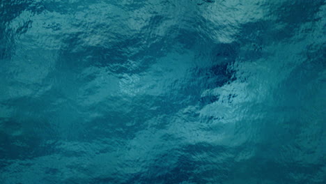 top-down aerial shot of the deep blue ocean with surface ripples