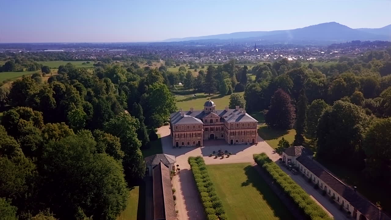 Approaching aerial view of 'Favorite' castle a Baroque pleasure palace near Rastatt surrounded by lush greenery on a sunny day