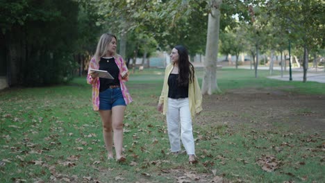 two women walking and talking in a park