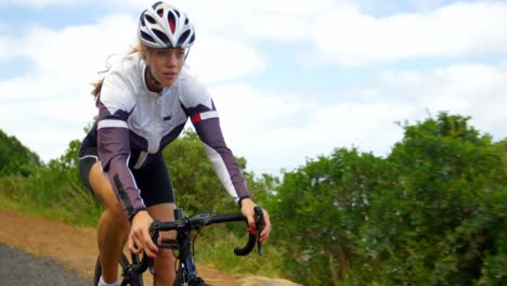 female cyclist cycling on a countryside road 4k