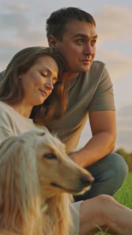 couple and dog enjoying a sunset stroll
