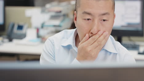 바쁜 회사 사무실에서 글로벌 데이터에 연결된 장치를 사용하여 컴퓨터에서 일하는 일본 사업가 임원 투자에 대해 매우 걱정합니다