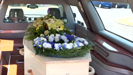 closeup shot of a funeral casket in a hearse or chapel or burial at cemetery