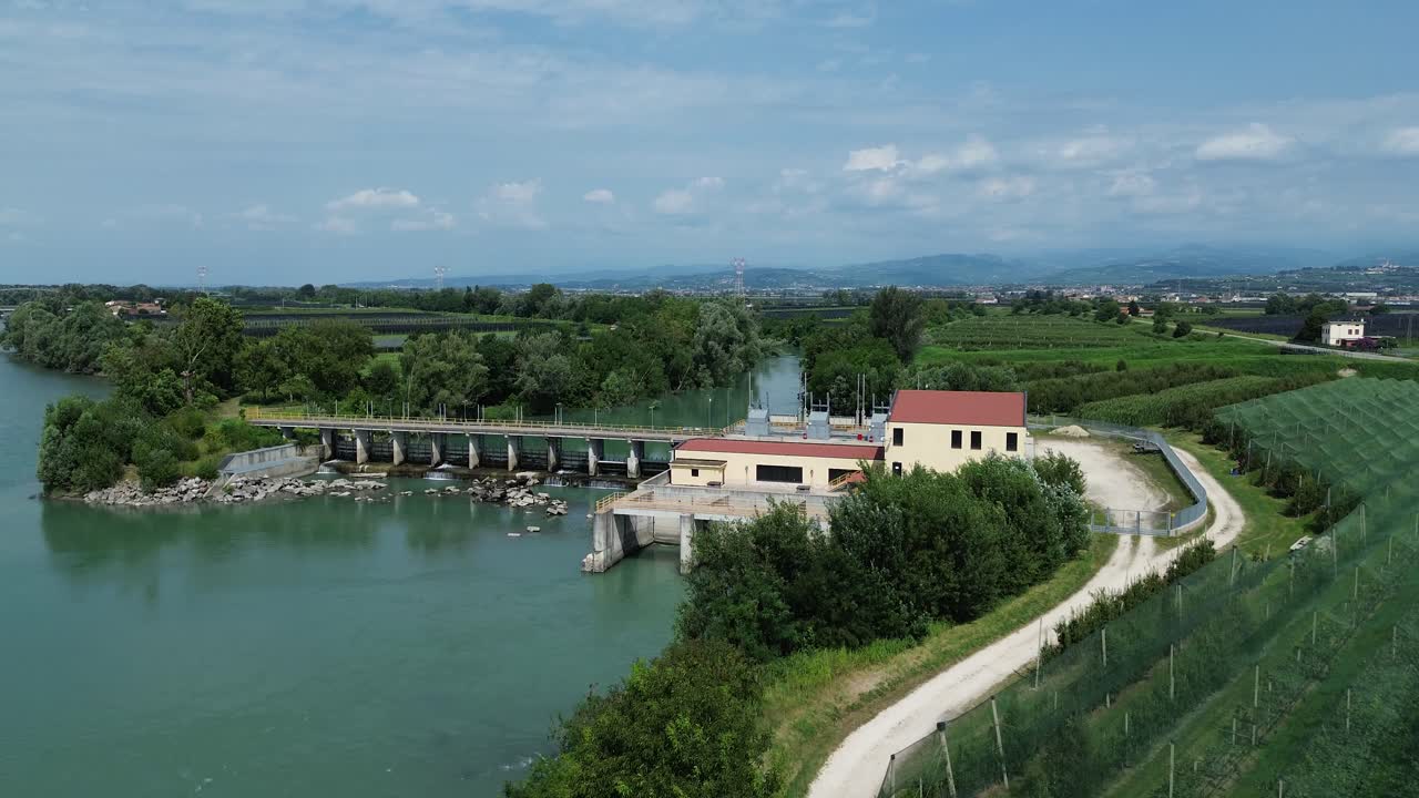 Una fluida ripresa aerea ascendente con drone della centrale idroelettrica di Belfiore d'Adige, Italia