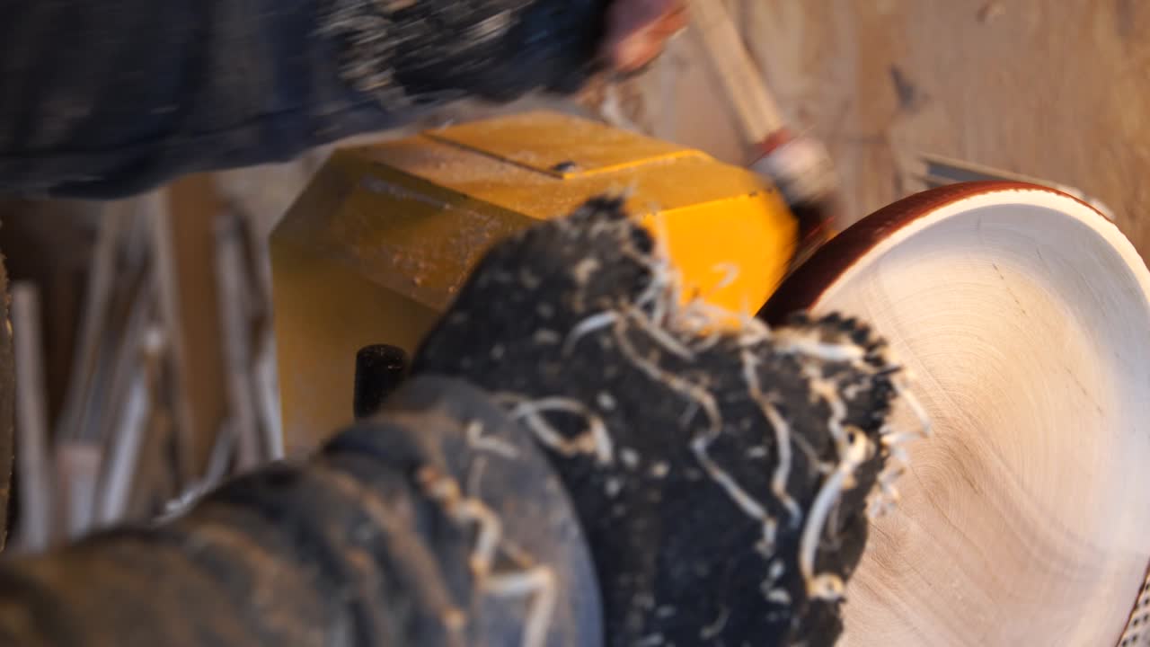 el carpintero pinta la placa de madera con el pincel.