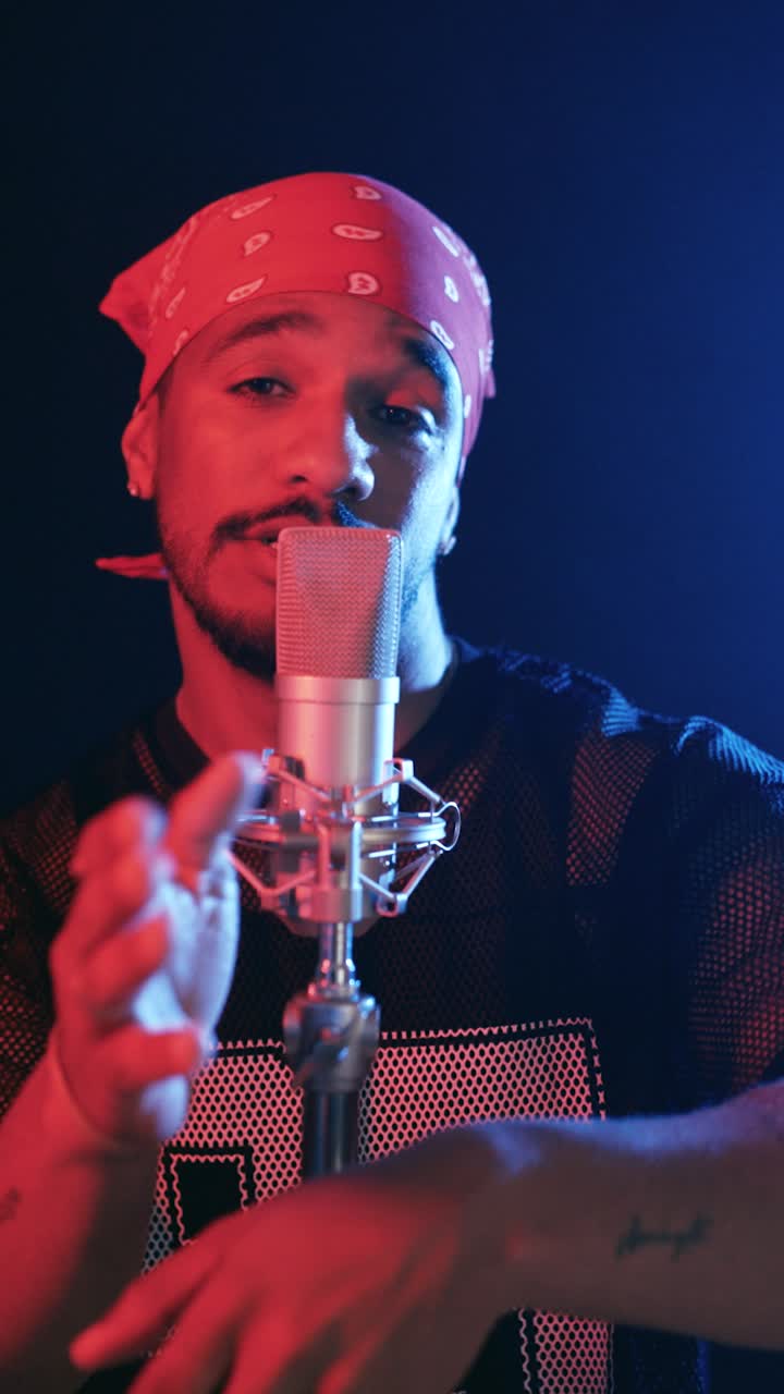 Giovane rapper che canta in un microfono professionale. Verticale