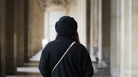 Eine-Frau,-Die-Allein-Durch-Den-Gewölbten-Korridor-Des-Louvre-Museums-In-Paris,-Frankreich,-Geht