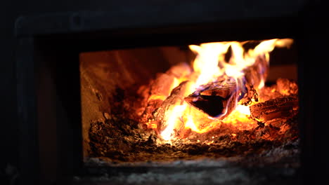 Glove-closing-the-lid-on-an-industrial-fire-place-with-raging-fire-inside