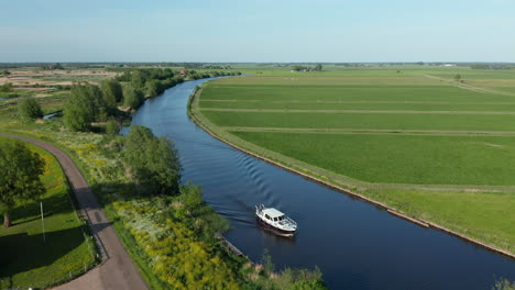 Volar-Sobre-Un-Barco-De-Lujo-Navegando-En-El-Río-En-Ossenzijl,-Frisia,-Países-Bajos