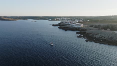 A-cinematic-aerial-view-of-Na-Macaret,-Menorca,-Spain-at-golden-hour