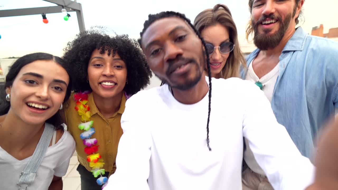 Group of friends taking a selfie on a rooftop party