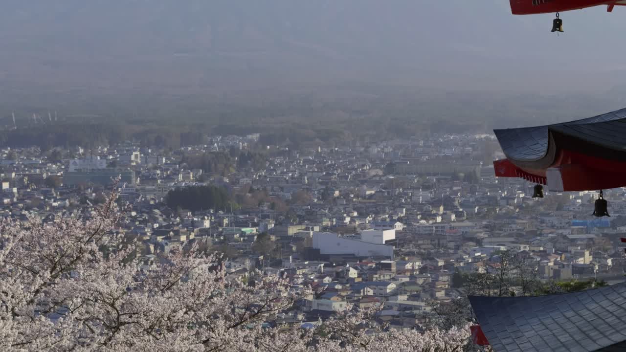 Cinematic close up tilt up over red Japanese pagoda with Mt. Fuji in distance