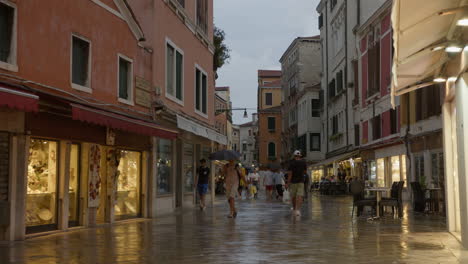 people walking down a street in venice, italy