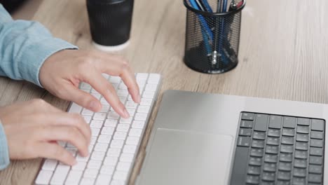 close up hand of a business woman typing keyboard desktop computer on desk office