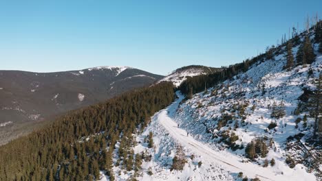 Drone-shot-of-winter-mountain-valley-covered-with-snow-in-Czech-Republic