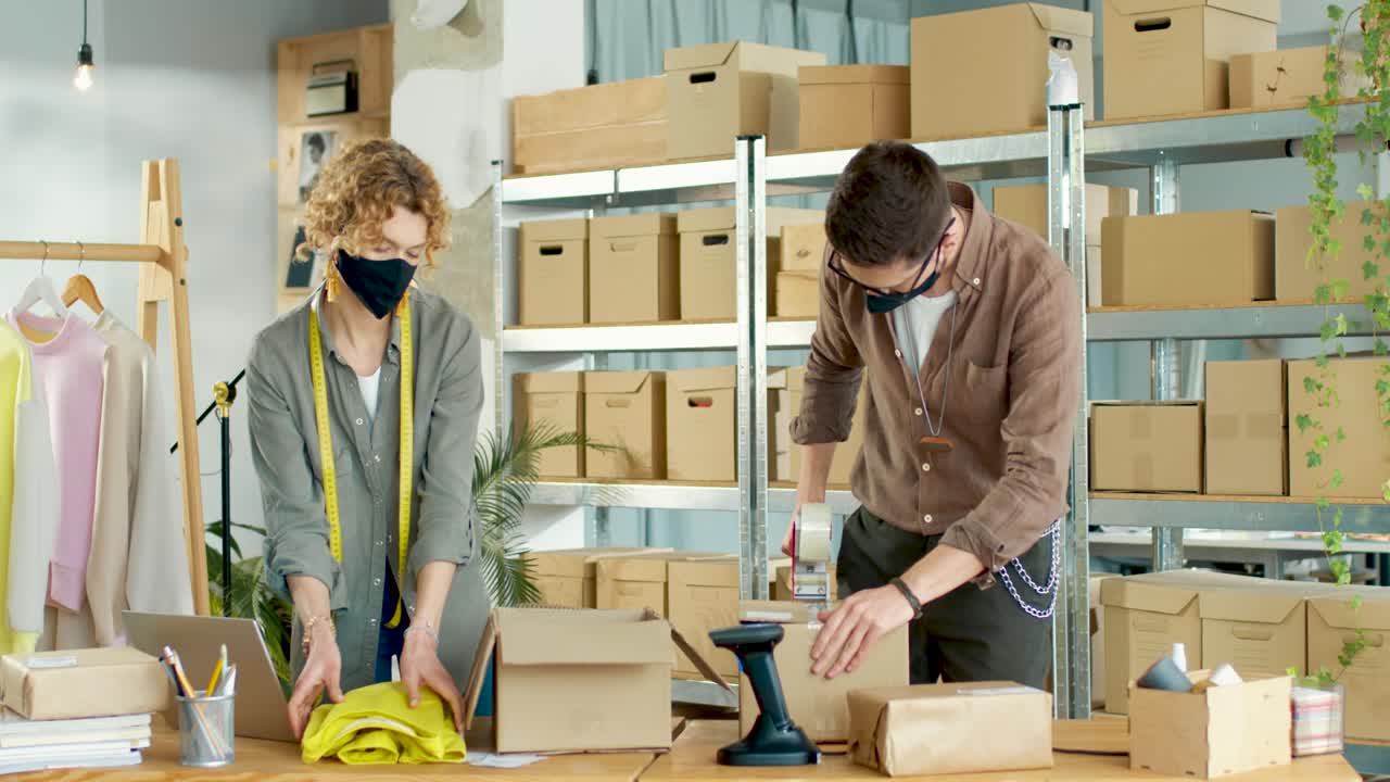 상점 창고에서 소포로 주문한 옷가게 포장에서 일하는 백인 젊은 여성과 남성