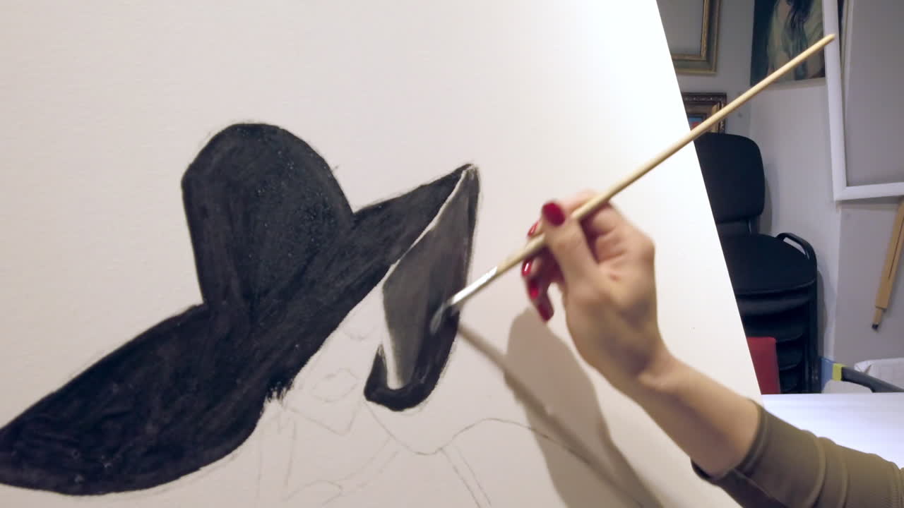 Close up of a woman paining on a paper at an art gallery workshop