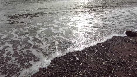 Panning-right-shot-of-the-sea-lapping-onto-the-beach-at-Teignmouth-in-Devon