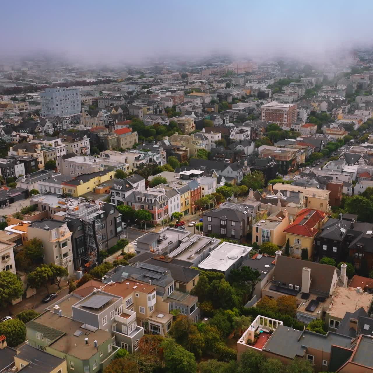 Densely built urban panorama of contemporary San Francisco at daytime. Thick mist spreading over the cityscape