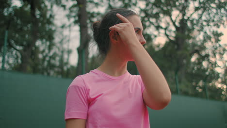 A-girl-in-a-pink-T-shirt-with-a-tennis-racket-in-the-ready-position