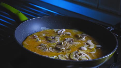 cooking eggs with sliced mushroom in a skillet